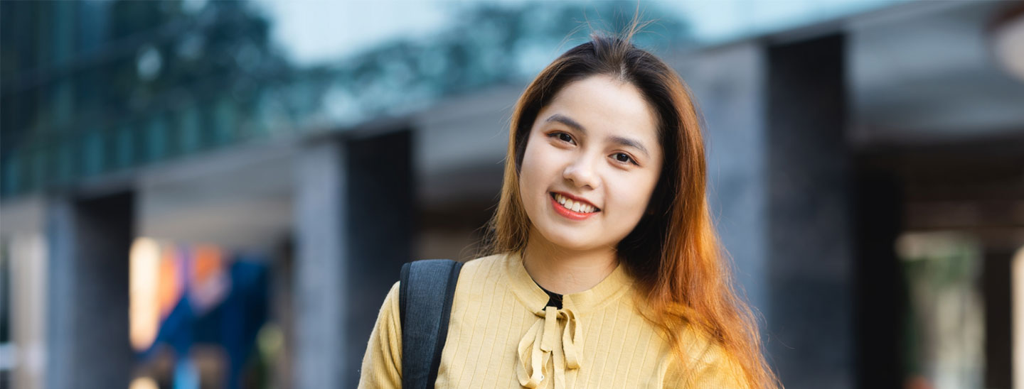 Female student outside holding books