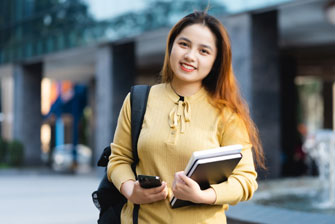 Female student outside holding books